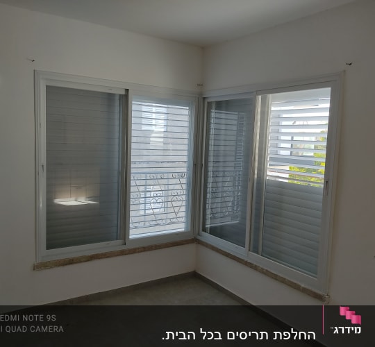 חלונות אלומיניום עם תריסים סגורים בחדר